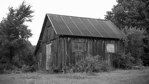 Wooden shed with tin roof in rural Ontario. Black and white. HD.