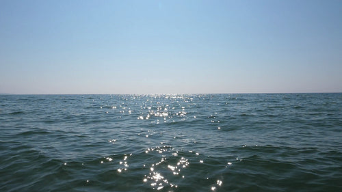 Slow motion sparkling lake water with copyspace. Mid level horizon. Lake Ontario. HD video.