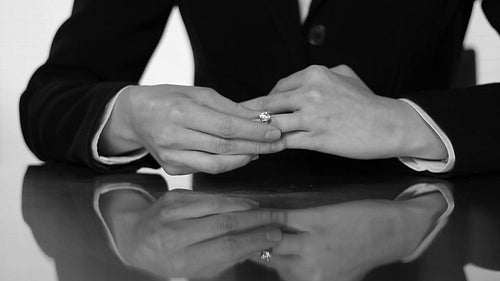 Closeup of caucasian woman's hands putting on wedding ring. Black and white. HD.