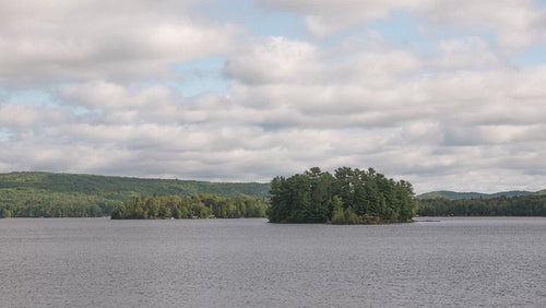 Time lapse of summer lake with island coming into light. Ontario, Canada. 4K.