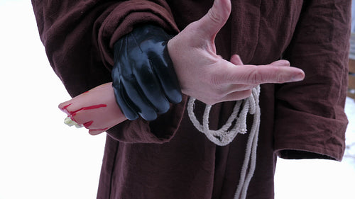 Horror hand. Man in monk outfit hold severed joke hand and wiggles fingers. HD.