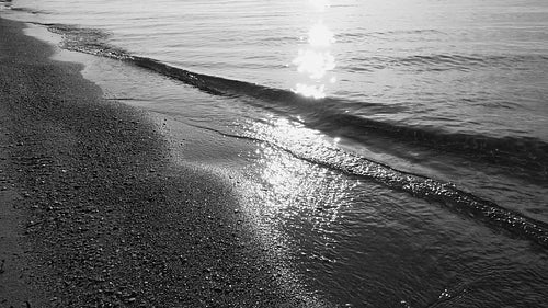 Slow motion sunlit wave and beach. Medium shot. Toronto Islands. B&W. HD stock video.