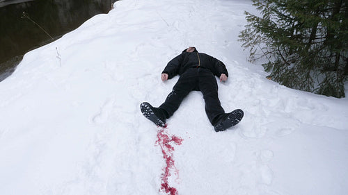 Dead guy lying in the snow with blood trail. Winter murder. Crime scene. HD.