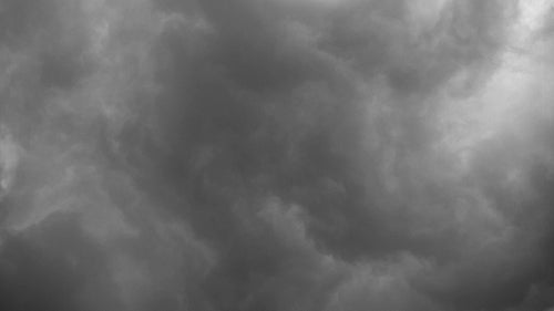 Swirling grey storm clouds moving overhead. Time lapse shot. Black and white. HD.