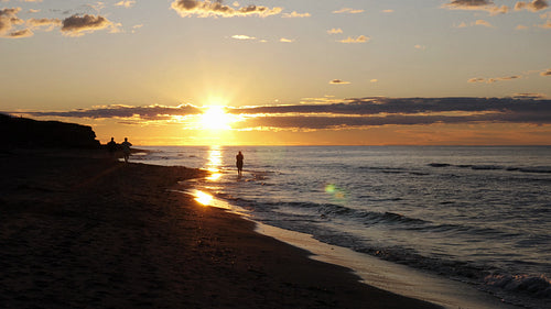 Prince Edward Island beach summer sunset. Silhouettes of people walking. Canada. 4K.