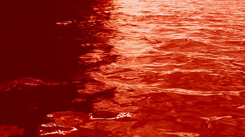 Blood lake. Slow motion ominous and spooky lake tinted blood red. Sunlit reflections. HD.