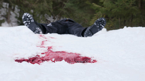 Winter crime scene. Pool of blood in focus with defocused dead guy beyond. HD.