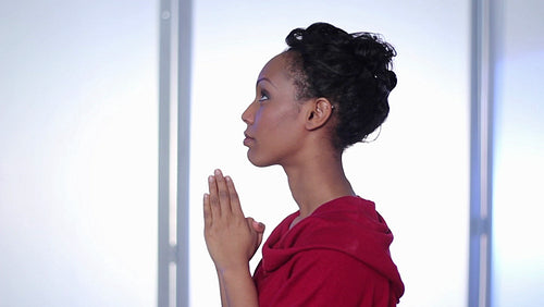 Attractive, young black woman prays. Profile view. HD.