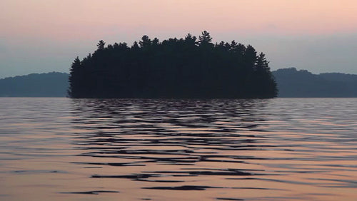 Morning island with dawn colours and water reflections. HD video.