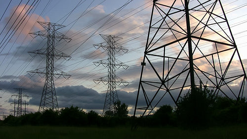 Hydro electric towers in silhouette at sunset. Toronto, Ontario, Canada. HD.