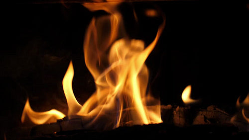 Slow motion yellow and orange flames. Closeup log burning in woodstove. HD.