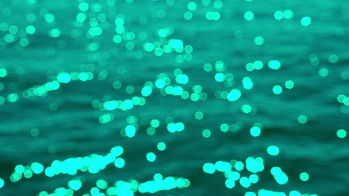 Slo mo defocused highlights on sunlit lake water. Turquoise tint. Lake Ontario, Canada. HD stock video.