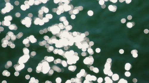 Slo mo defocused highlights on sunlit lake water. Blue green. Lake Ontario. HD stock video.