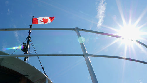 Canadian flag and sunshine. Ferry going from Toronto islands to Toronto. 4K stock video.