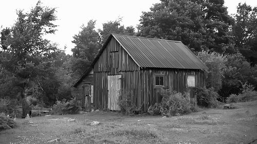 Wooden shed with tin roof in rural Ontario. Wide. Black and white. HD.