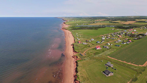 Drone aerial flight descent to beach front community. Summer in PEI, Canada. 4K.