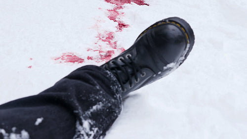 Corpse, boot and pool of freezing blood. Winter crime or accident scene. HD.