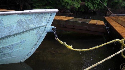 Detail of blue aluminum fishing boat and rope. Rain falling. Haliburton, ON. 4K.