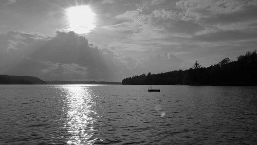 Moody slow motion lake with sunset highlights on water. Ontario, Canada. Black & white. HD.