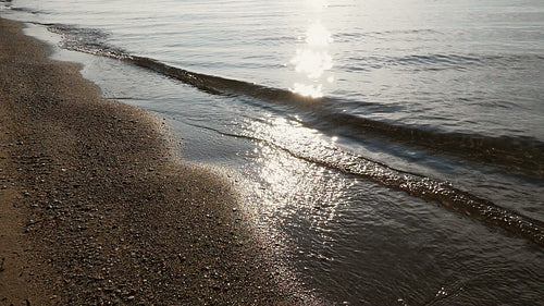Slow motion sunlit wave and beach. Medium shot. Toronto Islands. HD stock video.