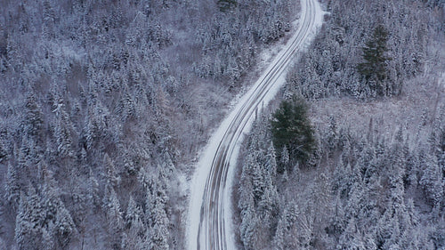 Birds eye view of curvy winter road. Drone aerial. 4K.