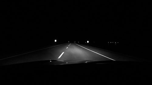 Driving at night on highway straightaway. Alberta, Canada. Black and white. HD.
