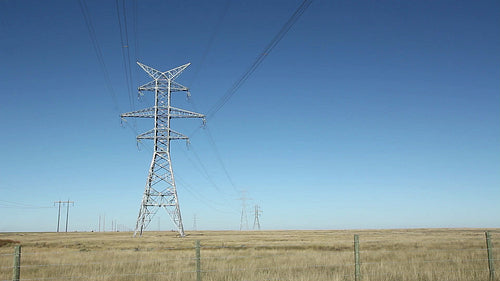 Big electrical pylons in the prairies. Traffic on horizon. Alberta, Canada. HD.