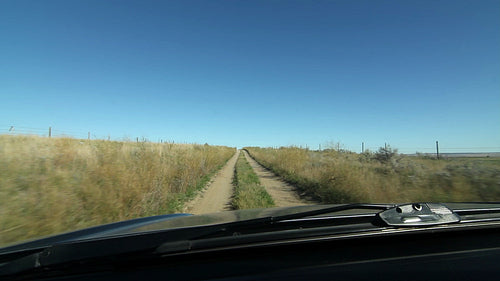 Driving on rough road between two fields. Saskatchewan, Canada. HD.