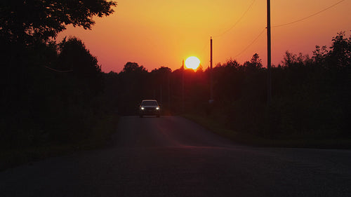 Country road sunset. Orange sky with car driving past. Kirkfield, Ontario, Canada. 4K.