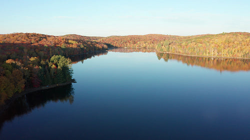 Drone aerial over smooth autumn lake. Ontario, Canada. 4K.
