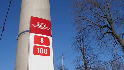 TTC bus stop on cement pole indicating numbered routes. Toronto, Canada. 4K.