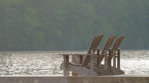 Three Muskoka chairs on summer dock. Muskoka, Ontario, Canada. 4K.