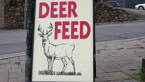 Deer feed sign outside hunting store. Ontario, Canada. HD.