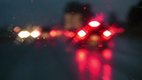 Defocused lights on rainy highway. Braking and slowing down. HDV footage. HD.