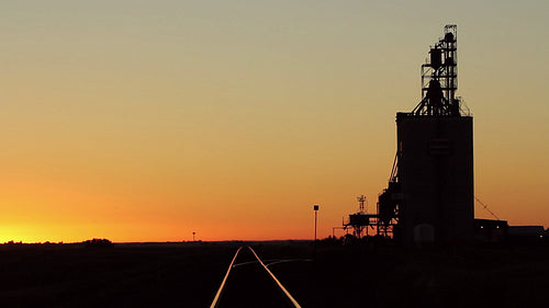 Grain elevator with train tracks at dusk. Saskatchewan, Canada. HD.