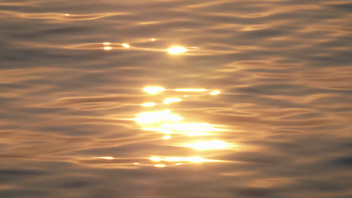 Slow motion sunset water. Beautiful texture with golden pink reflections. HD.
