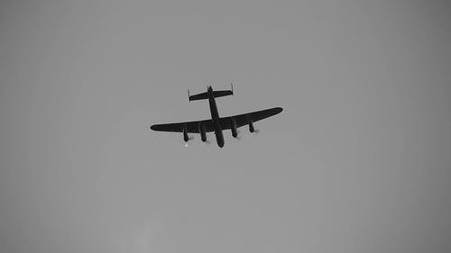 Avro Lancaster flies overhead. Black and white. HDV footage. HD.