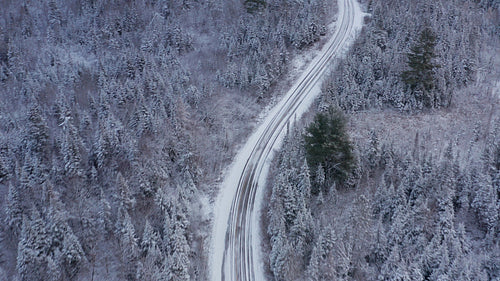 Birds eye view of curvy winter road. Drone aerial. 4K.