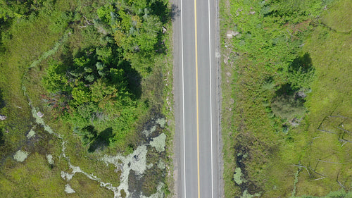 Drone aerial of summer highway. Tilt up to reveal landscape. Ontario, Canada. 4K.
